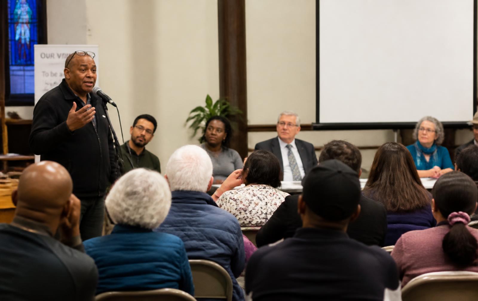Community members seated together at a neighbourhood meeting